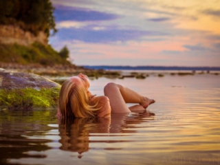 Aktifoto päikesetõus naine vees alasti