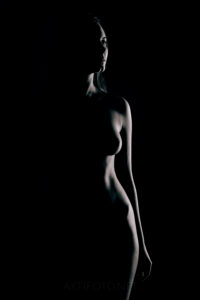 Kunstiline ilus aktifoto naise alasti kehast tumedate toonidega