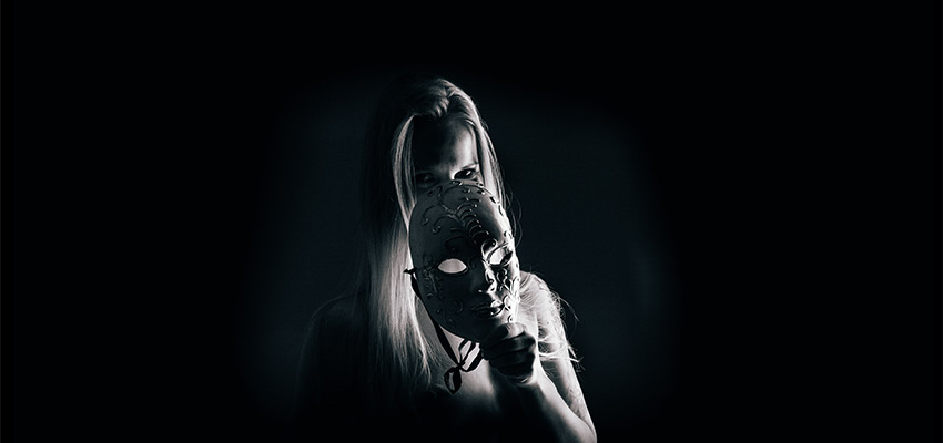 kunstiline aktifoto kus naine varjab oma nägu maski taha