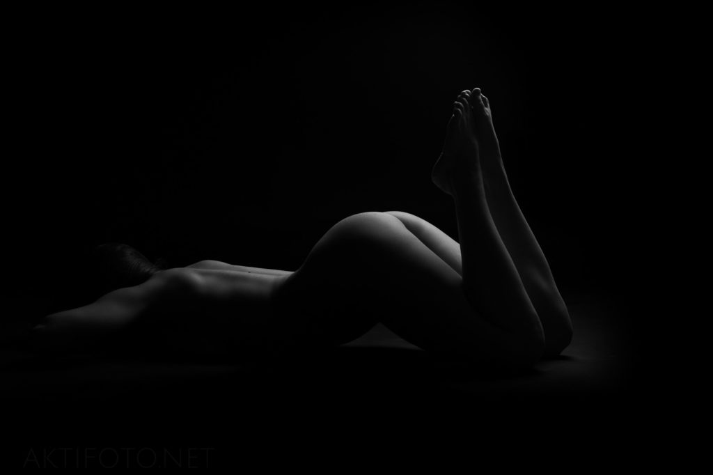 Kunstiline ilus aktifoto naise alasti kehast tumedate toonidega